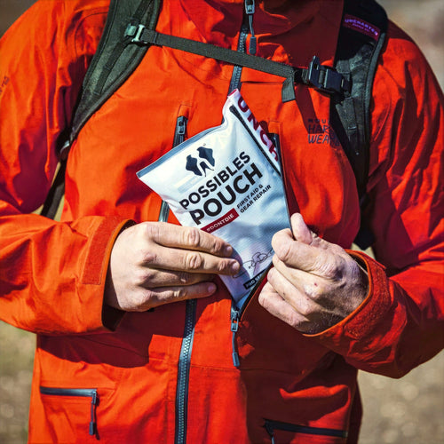 Person in a red jacket holding a possibles pouch