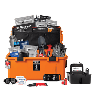 An open orange Basecamp 60L survival kit with various supplies and equipment organized inside, including food, tools, and emergency gear.