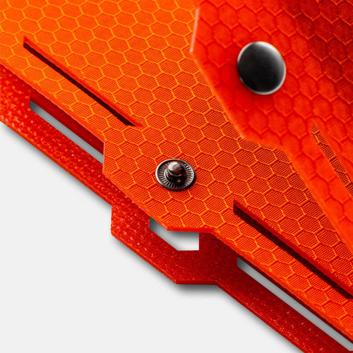 Dark Energy Spectre 18W rugged orange portable charger with hexagonal grip texture and metal snaps