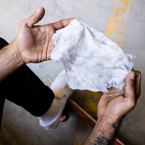 Klean Freak Body Wipes: person holds a visibly dirty wipe and grimy hands after use