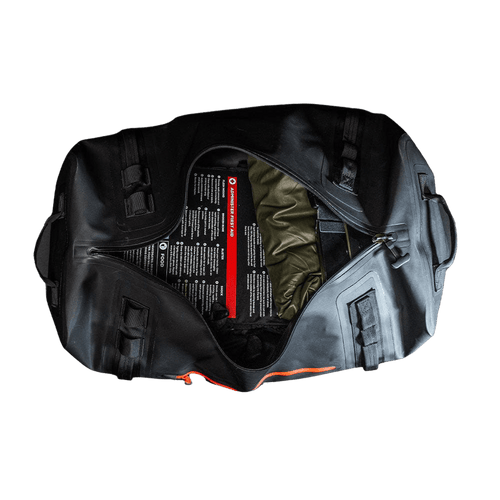 Flood Prep Premium waterproof emergency kit: open black duffel bag with visible first aid guide, food, and survival essentials