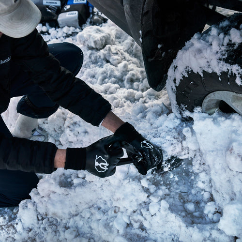 Insulated/Waterproof Cold Weather Gloves with logo used by person clearing snow from car tire for outdoor survival
