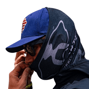 Uncharted Buff, dark gray neck gaiter with mountain graphic worn by person covering face, cap and sunglasses
