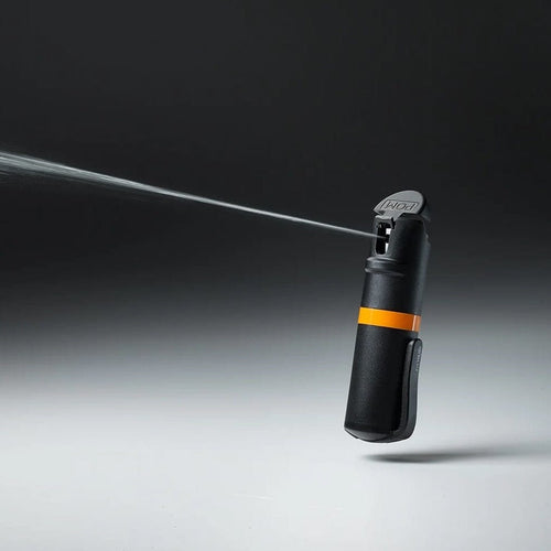 POM Pepper Spray, black personal safety spray with orange band spraying a focused stream